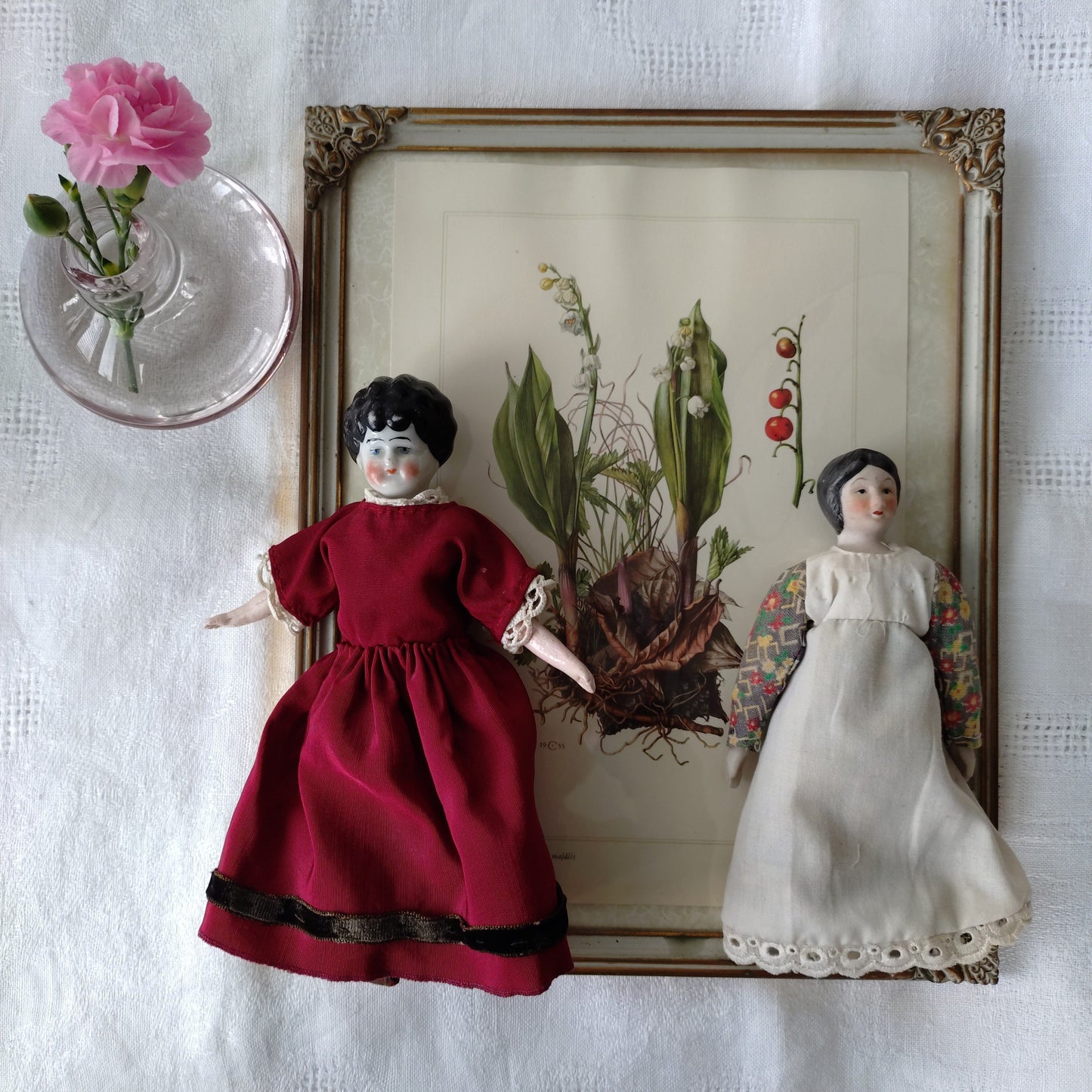 The doll in the red dress is approximately 21 cm high and likely dates to around 1900.
