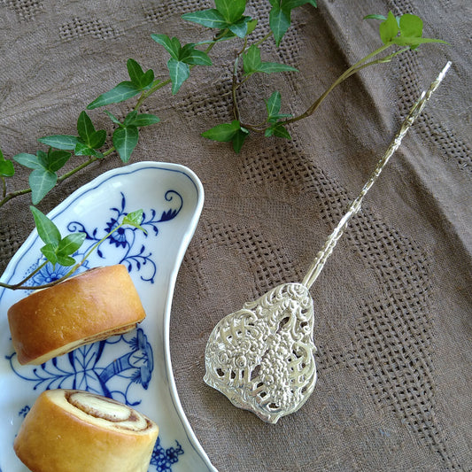 小さいバラが連なるシルバーケーキトング